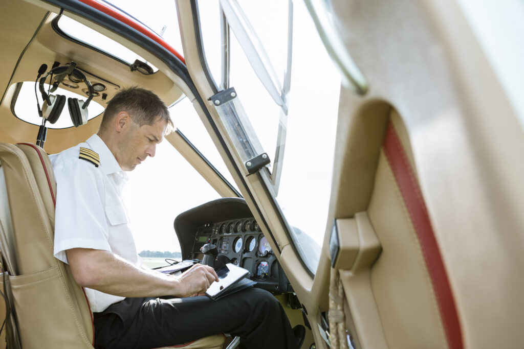 Pilot using tablet in cockpit of a helicopter
